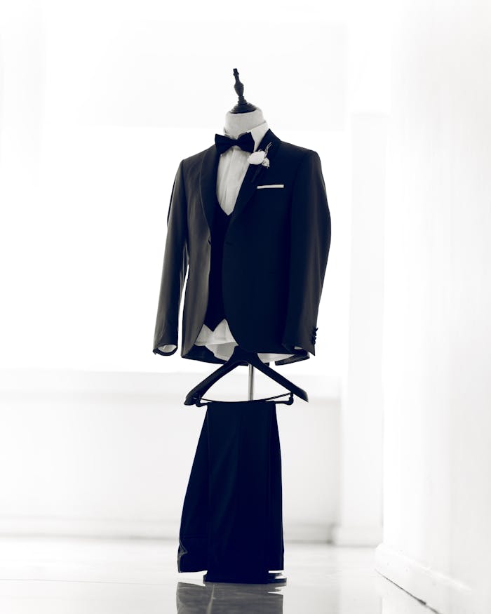 gallery-03 Classic tuxedo on a mannequin with a bow tie, perfect for formal events.